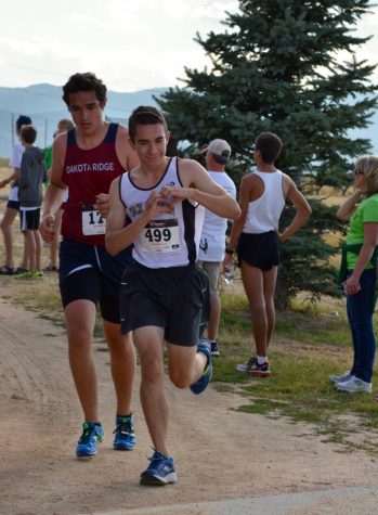 David Florez ’17 signals to watching fans as he competes in the JV race of Rock Canyon’s first cross country meet at Mountain Vista, August 26th.