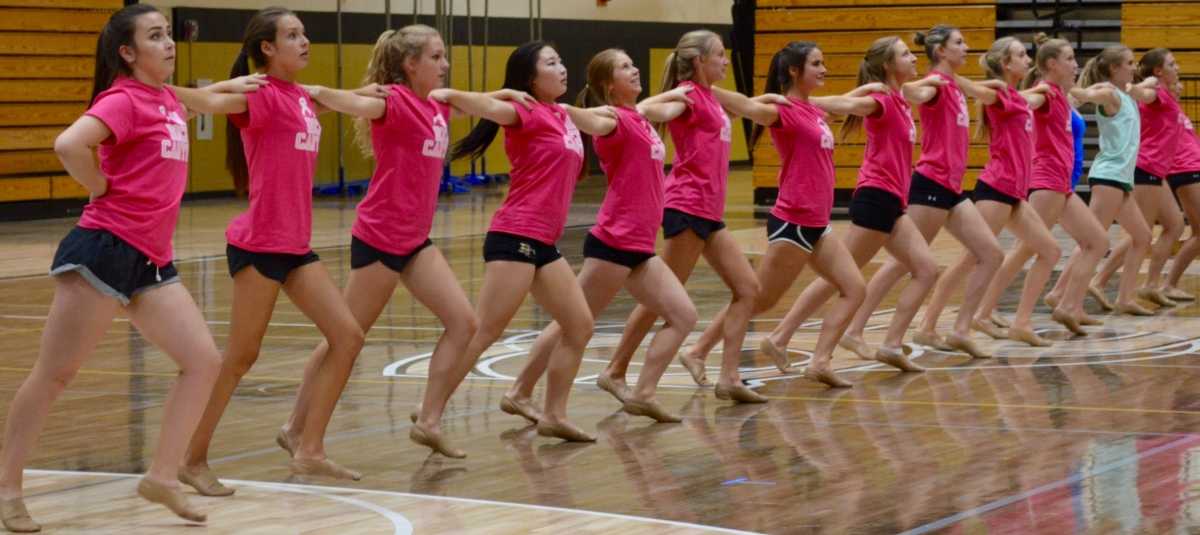 Sat. Oct. 8, members of the Varsity Poms team gather in the main gym to perform a kickline as a part of their most recent dance.