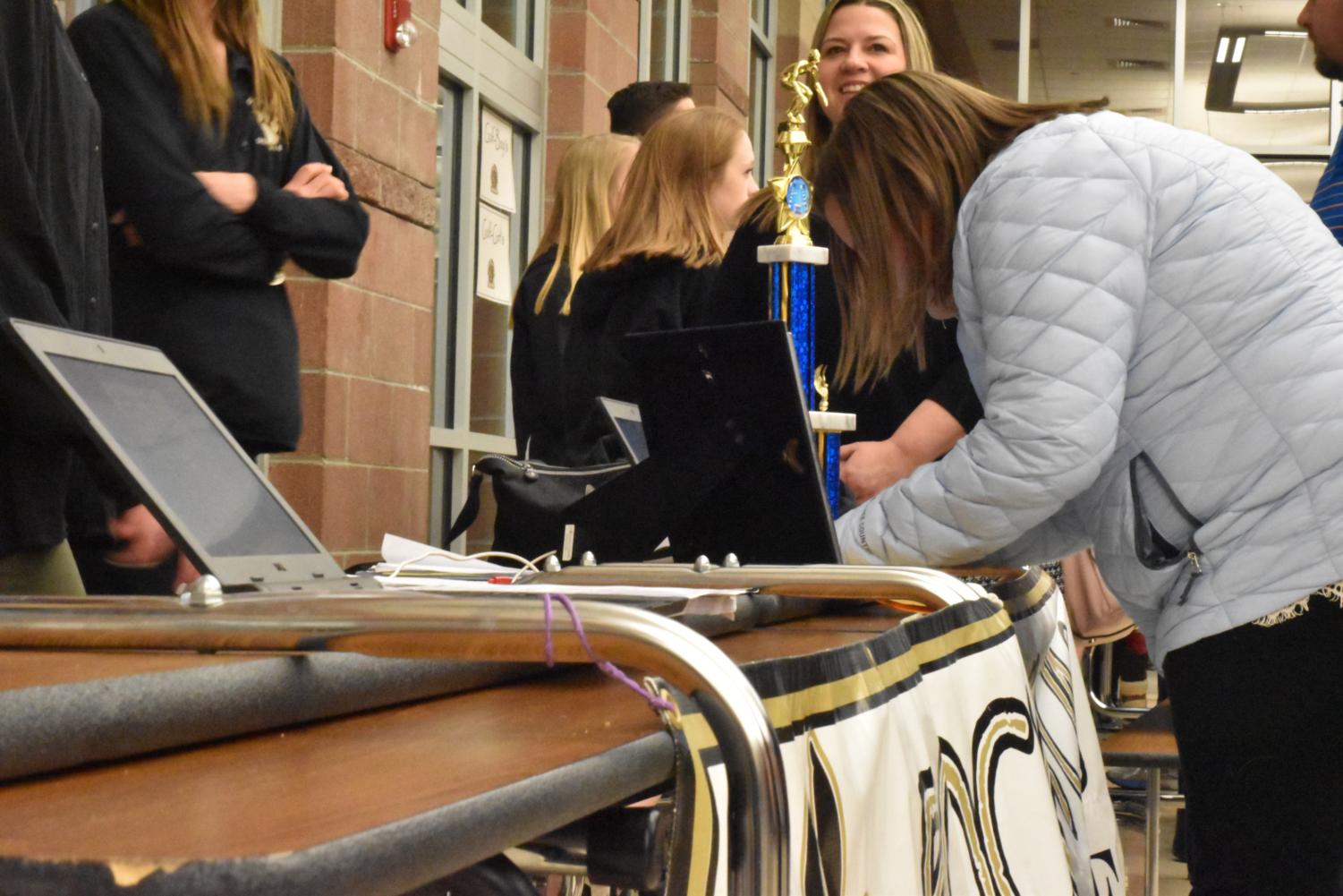 Middle school students and their parents fill out information sheets at the Swim and Dive table during the Rock Canyon 8th Grade Information Night, Wed., Jan. 24. Students interested in attending the school next year took part in the event to learn about the various clubs and activities that the school offers. Current high schoolers set up tables at which they aided the prospective students in deciding which activities would be best for them.