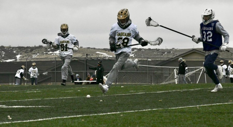 JV boys lacrosse player Ryan Grafitti ‘22 runs to the ball to beat his defender in the second half of the Cherokee Trail scrimmage on the turf field March 2. As part of fundraiser for their teams, the boys sold tickets for ten dollars each for the sandwich food truck during the scrimmages.