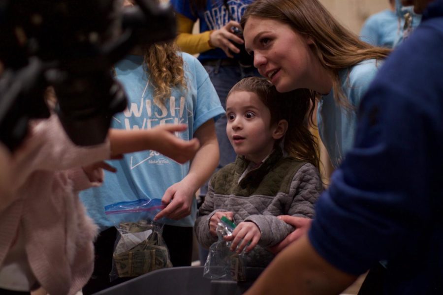 2019 Wish kid, Michael helps to separate cash from coins after the Miracle Minute at the Opening assembly March 1.