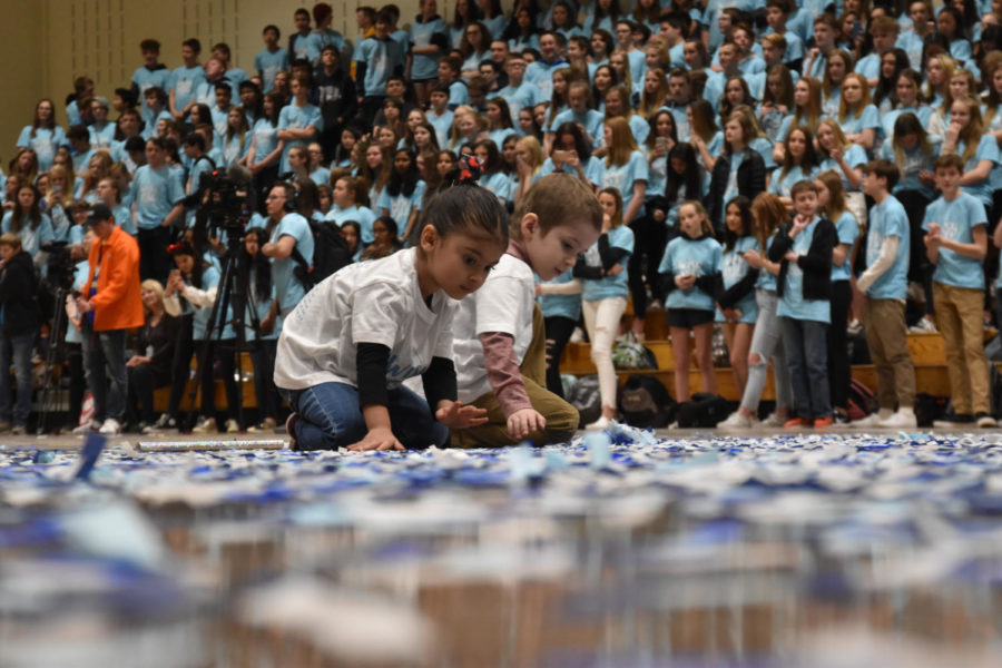 Wish Kid Michael McGuire and his sister, Genevieve McGuire, play in the confetti on the gym floor during the closing assembly March 8. The two spent the rest of the assembly romping in the confetti Student Council dispersed throughout the gym.