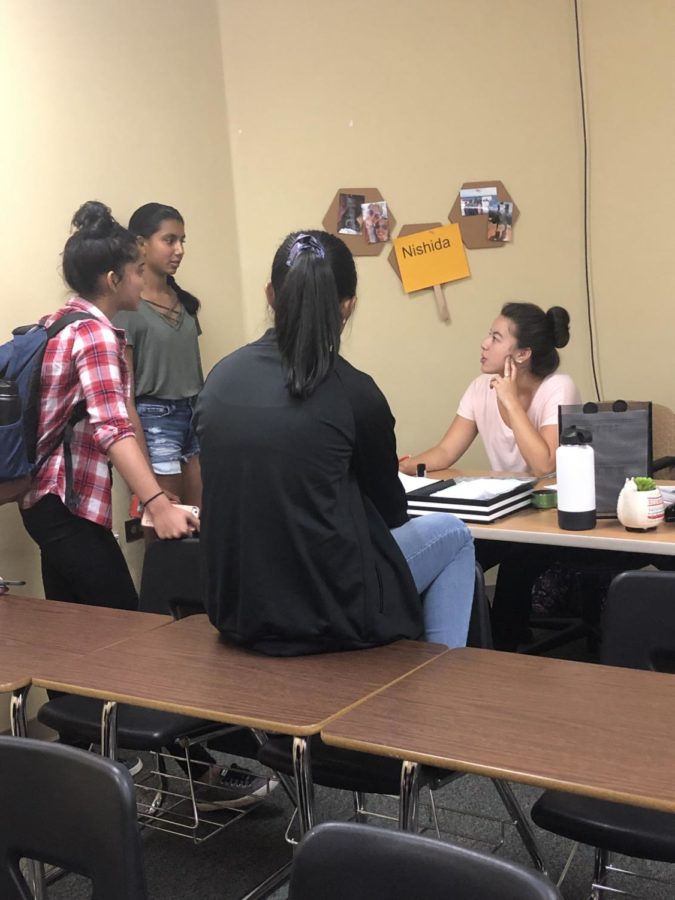 Teacher Grace Nishida helps out students Nikhila Narayana  ‘22, Rhea Jaxon '22, and Amira Badruddin '22 during access in room 9000A Aug. 29. 