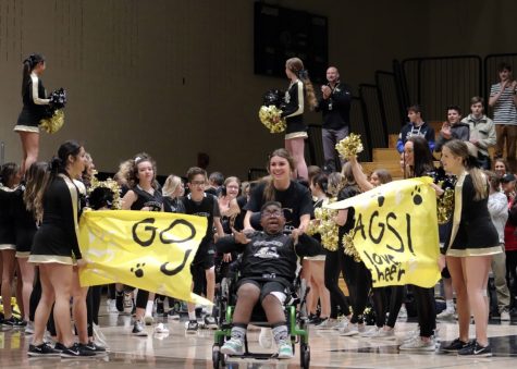 David O’Keefe ‘23 bursts through the “Go Jags!” banner in the gym during his team’s introduction at the First Annual Unified Basketball Game Jan. 22. In the past, the Unified Basketball team’s basketball hoops were trash cans, but their equipment was upgraded with adapted basketball hoops for optimum accessibility for all students. “We’re trying to change the culture of Unified Basketball. Every day, it’s a challenge for them to be heard, to be respected and to compete in sports, but they push themselves every day past all those challenges,” Unified Basketball Coach Jerome Price said.
