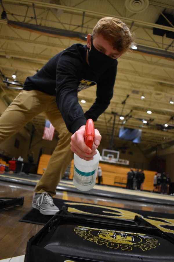 Ryan Gerlitz ‘22 sanitizes chairs after the dual meet against Rangeview High School Feb. 20. All of the chairs set out had to be sprayed and wiped down after use. “Sanitation is more important this year than any other, as without it we wouldn’t even get a season. To do this, we thoroughly wipe down the mats before every practice and during competitions at home we are sure to clean the chairs as well. This all ensures that we stay healthy and get the longest season possible,” Gerlitz said.