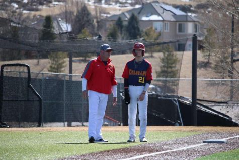 Brayden Duman 23 converses with assistant coach Dean Adams at third base after hitting a triple during a Spring Training Game. 