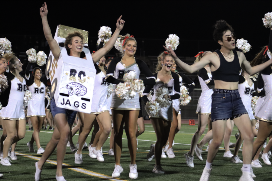 On Sept. 24, Kyle Mackzum ‘22 and Jack Duong ‘22 celebrate during the finale of their halftime manpoms homecoming performance.
