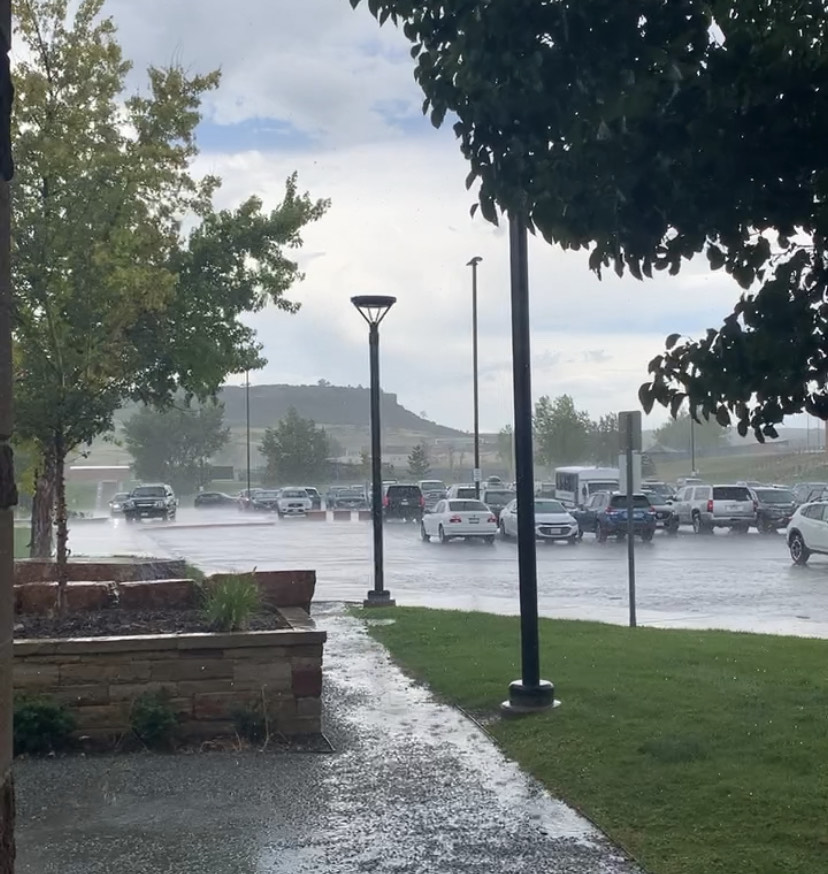 The upper parking lot floods with rainwater during a brief but heavy rainstorm. Heavy rain and flash flood warnings made driving and walking home potentially dangerous. The rain lasted from about 3:00 p.m. to 3:45 p.m.