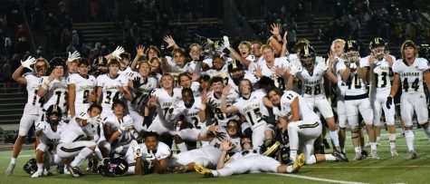 The varsity football team celebrates together after their 28-17 win against the Warriors Sept. 23. 
