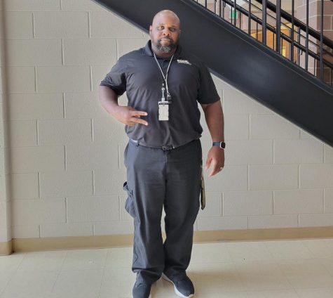 Security Guard JT Adams stands by the stairs by the security desk. Adams started working in schools because he enjoyed helping students. “I just like being in a good environment,” Adams said. “I’ve always wanted to work with kids and help kids so that’s why I’m here.”