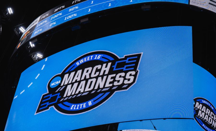 The jumbotron displays the NCAA March Madness logo. 

Photo courtesy: Jacob Rice, free to use under the Unsplash License.