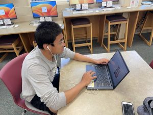 Nathan Shrestha '25 works on an assignment in the LMC May 12. Shrestha utilized his time before his track and field meet to finish a presentation for Chinese IV. “Anytime I’m free, I make sure that I don’t have any extra assignments that I would have to cram at the last minute,” Shrestha said. 