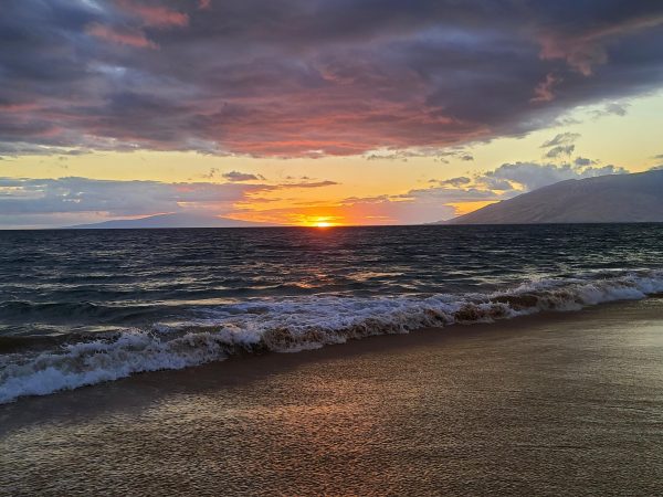 A beach sunset photo captures the Hawaiian island Lanai in the background in Maui 2021. Alexis Savas and her husband got Hawaiian shaved ice and walked along the beach, watching the sunset. “We would just eat our shaved ice and relax by the sunset and I would always try to capture the green flash that happens right before the sun goes down,” Savas said.