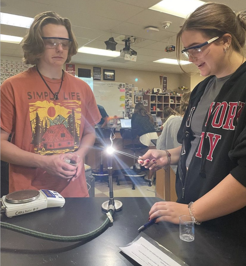 Kendall Maurer ‘25 and Jacob Harris ‘25 perform an experiment in Destiny Barreras’s first period Chemistry Aug. 28. Students did a total of eight experiments during class to learn about the difference between physical and chemical changes. Maurer used forceps to hold a ribbon of magnesium over a lit Bunsen burner to light it on fire. “This lab was a lot of fun to do because Ive never used a Bunsen burner before, which is really cool. We are doing all this work to help us understand what physical and chemical changes are,” Harris said.
Reporting by: Claudia Llado