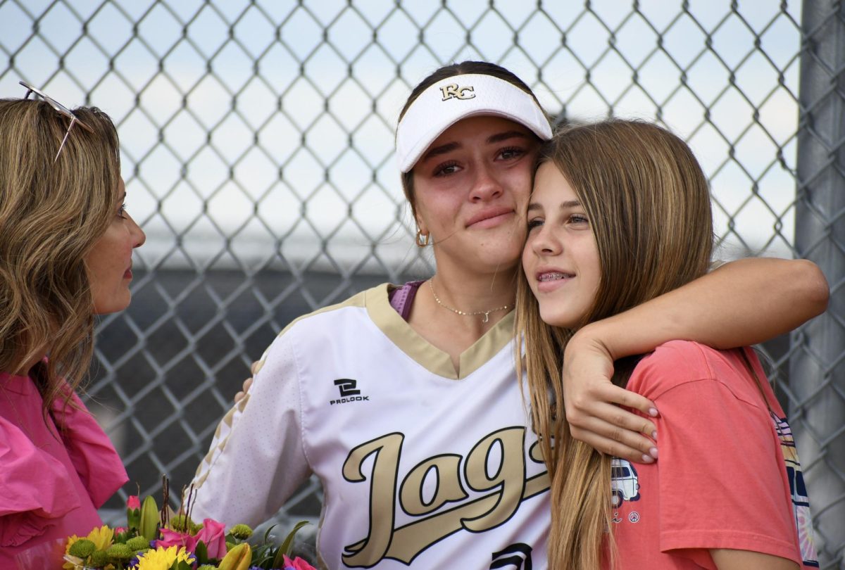 Varsity softball captain and first basemen Julia Hay 24 hugs her younger sister during Senior Night before the game against Chaparral High School Oct. 3. The three seniors on the team were given flowers, painted rocks and speeches from the younger players. It wasn’t great that we lost the game, but I had a fun time and loved the speeches. I’m sad to leave the team because I love the players and the coaches, Hay said. I am done playing at a high level but hope to join a club team in college.