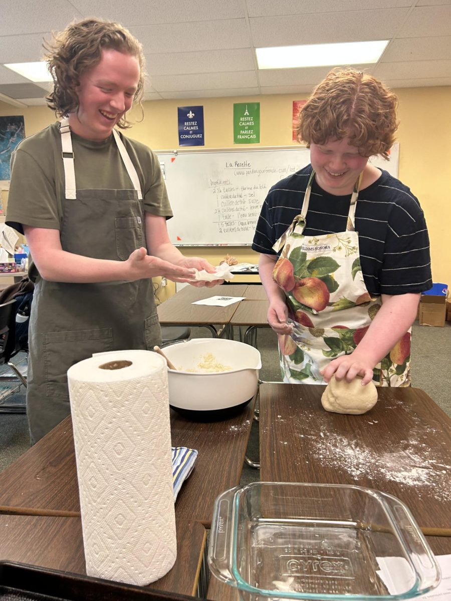 Charl Blom ‘26 and Emma Lewandowski ‘25 knead their bretzel dough during a French National Honor Society activity in Alexis Savas’ room Oct. 26. Eight members showed up to the event and cooked Alsatian Bretzels from 3:00 p.m. to 5:20 p.m. “I hope to make them at home maybe in the future with my family since they also enjoy these pretzels,” Blom said. 