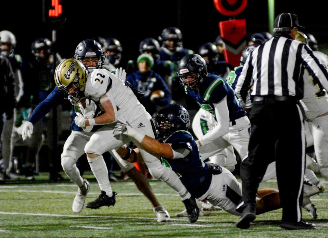 Running back Tyler Meyer 25 runs with the ball while a ThunderRidge Grizzlie player holds onto his legs Oct. 27. Meyer averaged a total of 10.8 yards during the game and scored two touchdowns. “My main focus [is] looking for open space and trying to get through some hardships,” Meyer said. 