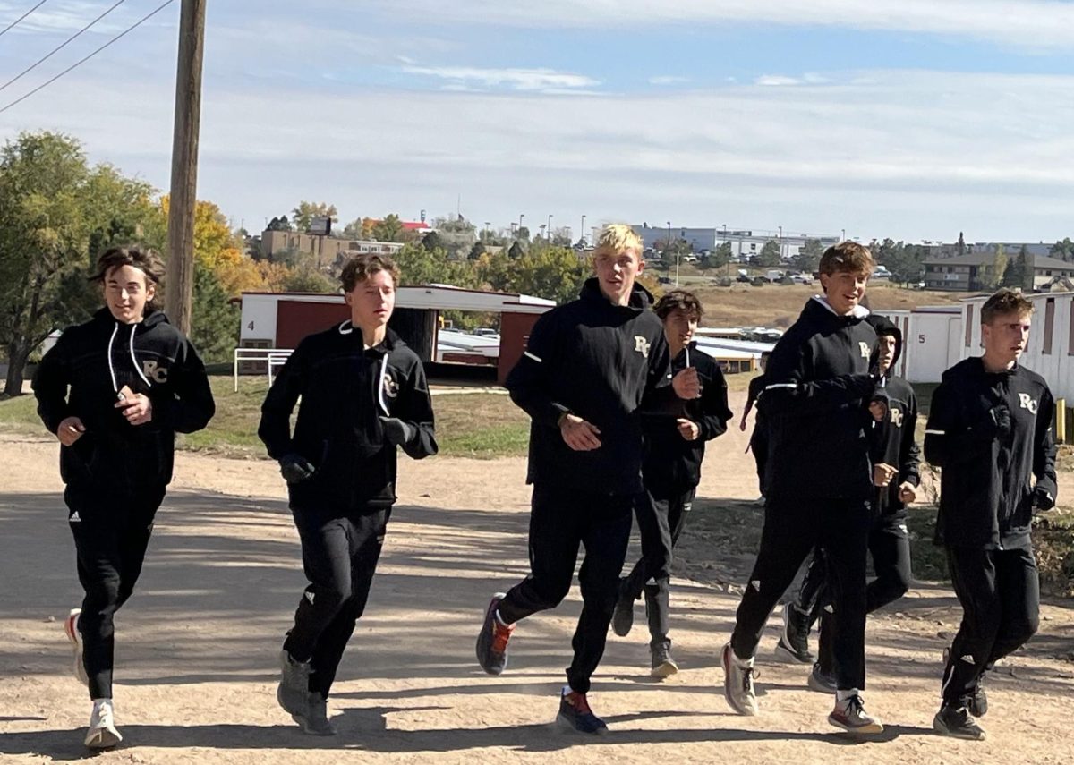 Varsity runner Dylan Laity ‘26 and fellow team members warm up with the state-qualifying Jaguar cross-country team before the final race of the 2023 season. The team jogged the race course together before racing.