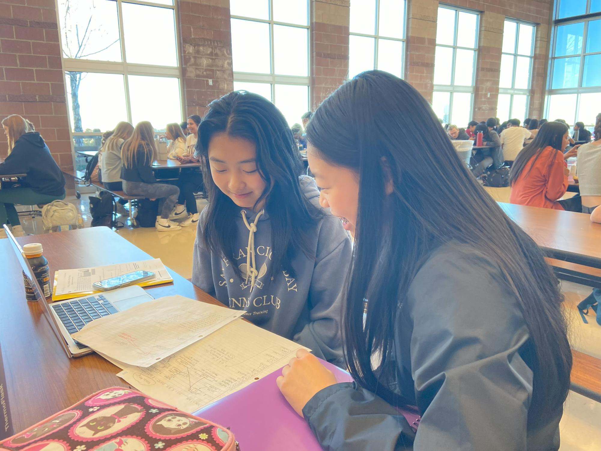 Hannah Zhang ‘26 and Olivia Fang ‘26 study together during lunch in the cafeteria Nov. 10. Zhang reviewed material from her AP Computer Science class before an upcoming quiz.  “I like studying in the cafeteria because I’m able to work while talking with friends,” Zhang said. “If I need help with something I can ask them and when I dont have homework I can talk with them.