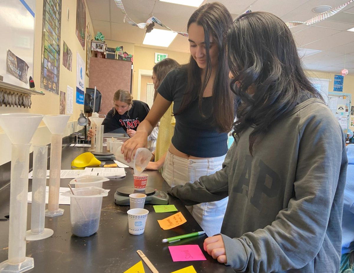 Ria Hellyer ‘26 and Olivia Fang ‘26 measure the volume of a 30 gram sample of sand in a Soils Lab during AP Environmental Science Nov. 13. The purpose of the lab was to understand how different types of soils have variations in certain traits such as percolation and density, which affect farming and agricultural methods. Clay and silt also underwent similar procedures of being weighed and having their volumes measured. Students filled out a given packet with their observations and also participated in calculating equations to understand the effects of both chemical and physical weathering on certain materials as well as how land is used. “The lab really helped explain the different layers of soil and how it relates to the overall soil health,” Hellyer said. “I think it’s important that we know this so we can help sustain our planet.”