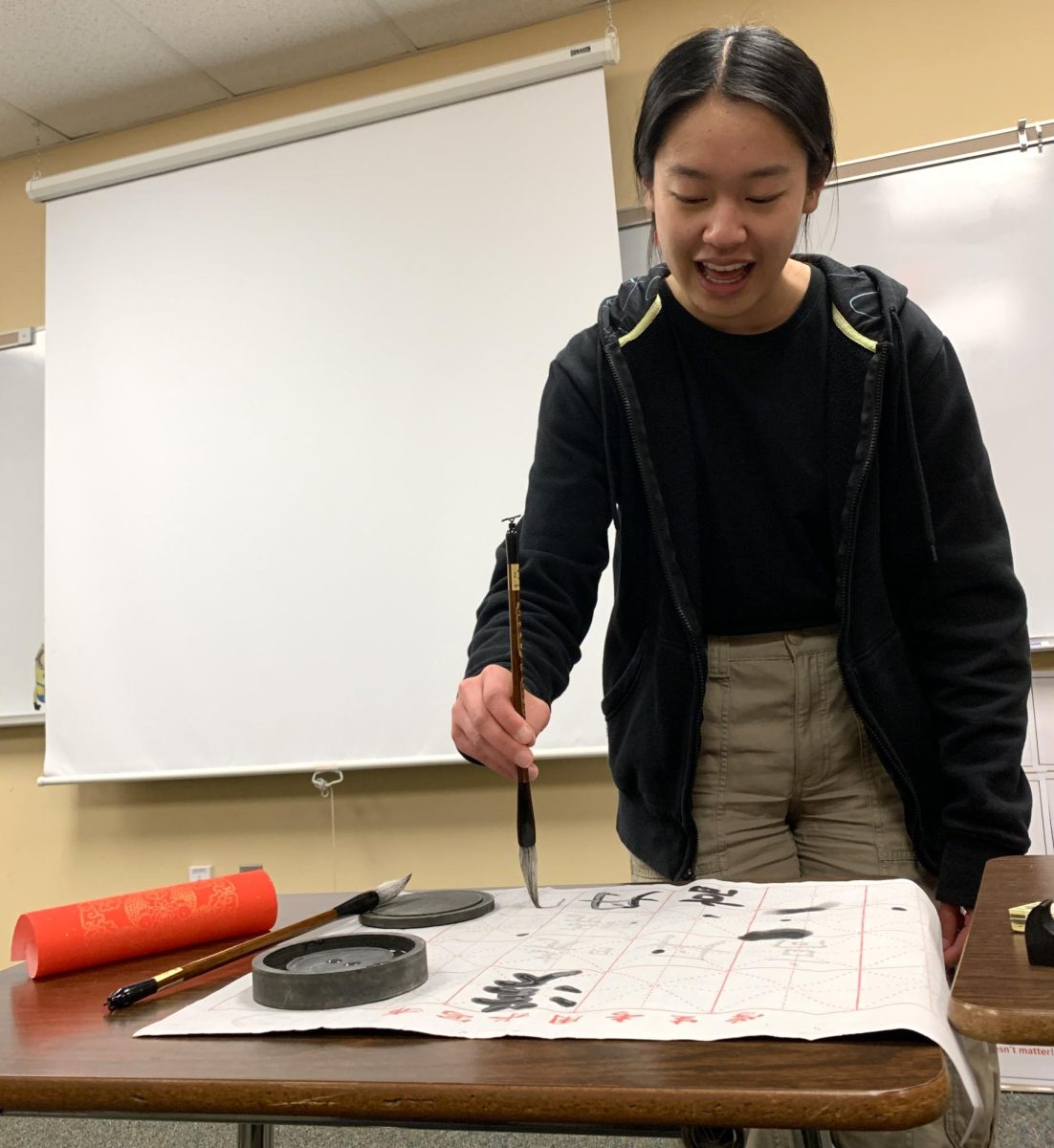 Chinese National Honor Society (CNHS) Co-President Annie Gao ‘24 uses a paintbrush and colored water from a calligraphy kit to paint Chinese characters onto a sheet during a CNHS activity after school Nov. 27. Each month, CNHS hosts a meeting that features a lesson on the language, culture and more, followed by an activity relating to that lesson. “I think [calligraphy] is a really cool art form, like especially in more traditional Chinese art you see a lot of calligraphy, so it’s just kinda cool to connect back with our cultural roots,” Gao said.