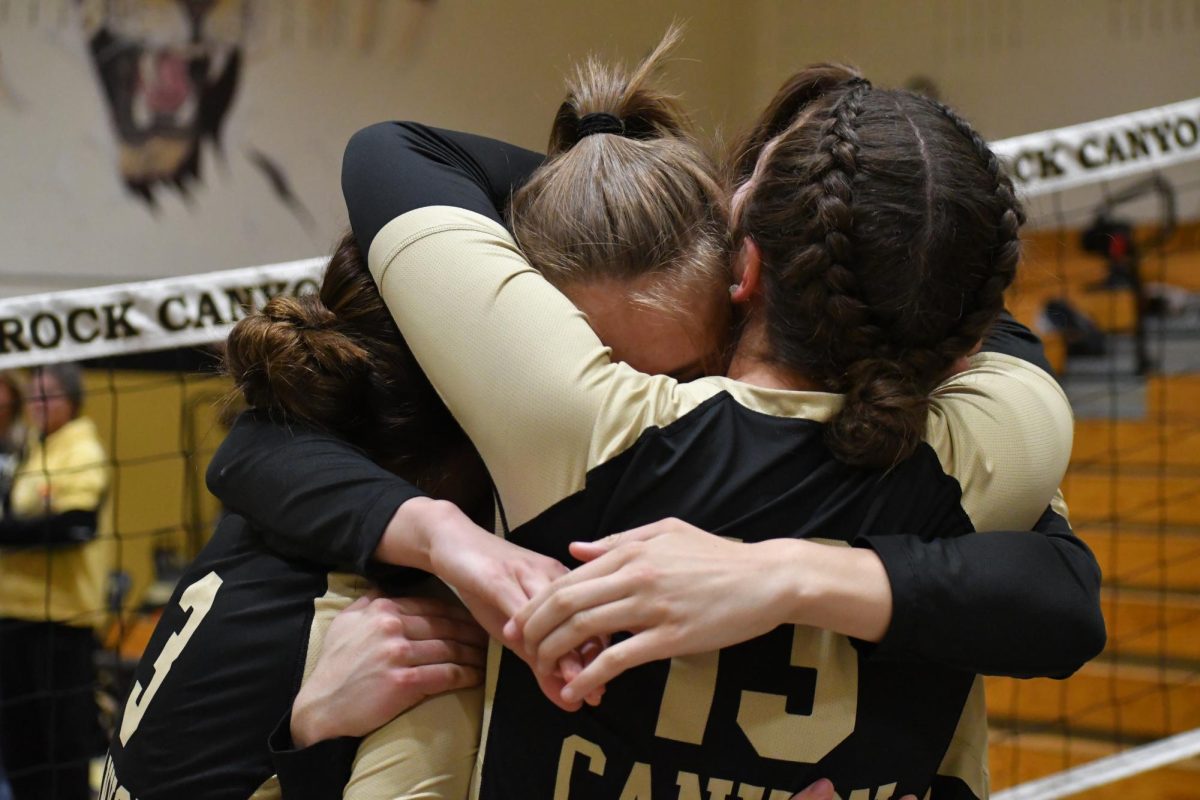 Varsity girls volleyball captain Addie Waller ‘24 hugs her teammates Julia Holmes ‘24, Gannon Figueroa ‘24 and Lindsay Heyliger ‘24 after winning in Regionals on Nov. 3. The team beat Lakewood and Denver South High Schools to qualify for State.