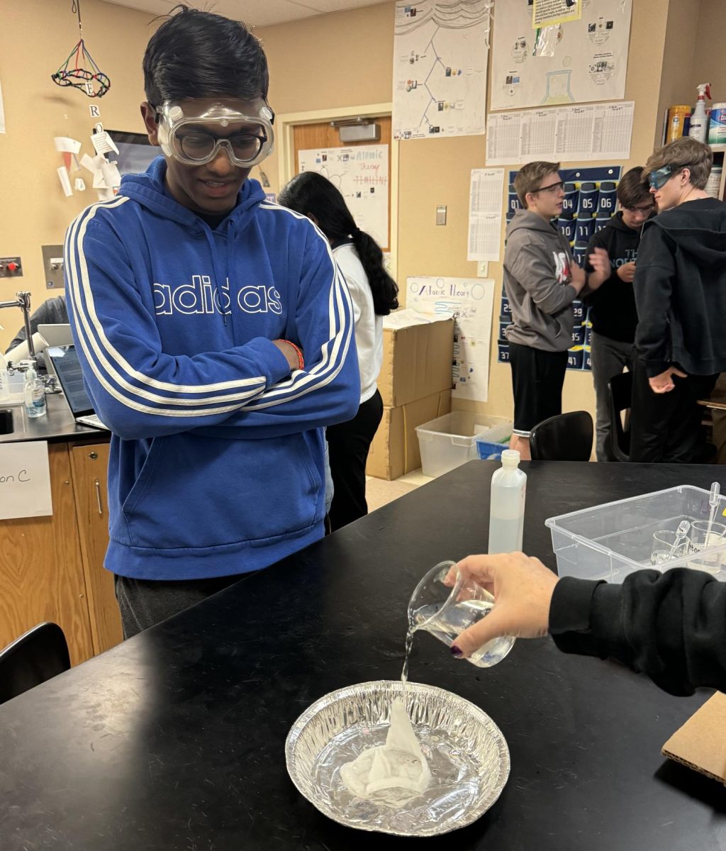 Sri Nama ‘25 watches Chemistry teacher Kerry Reilly conduct a chemical reaction on Styrofoam during period three AP Chemistry Dec. 7. The experiment was used to show the soluble capabilities of Styrofoam as a solid, and was a fairly quick chemical reaction. “These experiments are really why I chose to take AP Chemistry,” Nama said.