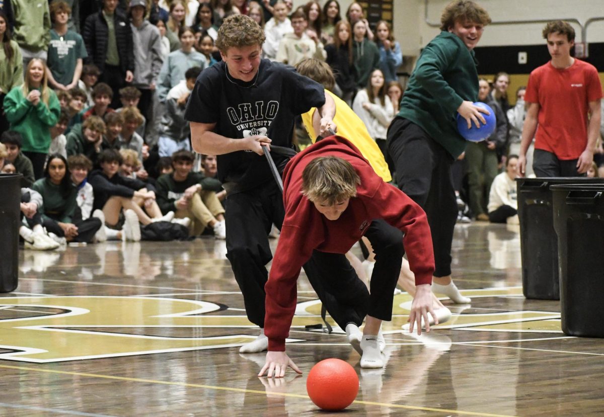 Grabbing at the exercise bands, Jonas Thelander ‘24 pulls Emmet Dunham ‘25 back from grabbing dodgeballs during Hungry Hippos Jan. 19. Before the game began, participants were tied together with the bands and had to take their shoes off. “I enjoyed being apart [the game]. I didn’t really know the rules, so I was just trying to grab as many as I could,” Thelander said.