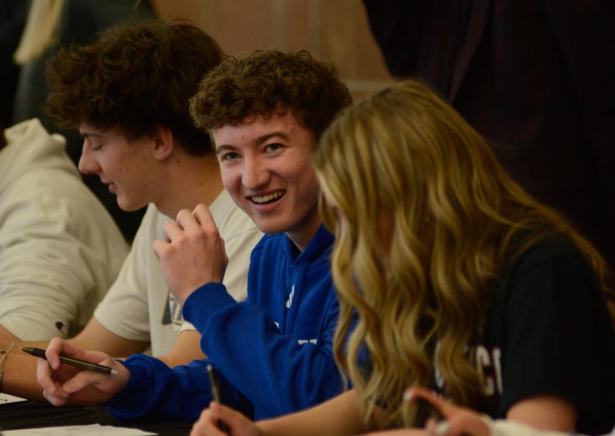 Varsity lacrosse commit Cale Maguire 24 smiles while talking to varsity soccer commit Gabby Beaudry 24 during the signing ceremony Feb. 7. Maguire committed to play for Lynn University, a Division I school in Boca Raton, Florida. I have always loved Florida and have known I will end up there, Maguire said. I’m a huge fan of the warm weather year-round. I also love how close I will be to the beach. The deciding factor as to why I chose this school is it checked all my boxes. I wanted to play lacrosse, have good academic opportunities and be in a warm area.