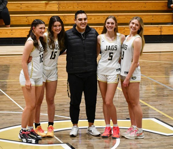 Varsity girls basketball seniors Sarah Davis, Sienna Pillsbury, Kate Fehr and Emily Feiman stand with athletic trainer Taylor Quenzer during Senior Night Feb. 16. Each senior had the opportunity to select a staff member to honor that made the most impact in their lives. The four faculty selected were Quenzer and science teachers Susanne Petri, Jenny Wills and Payton Holloway.