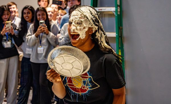 After being pied, Colorado TSA President Shreya Ganesh ‘24 screams and takes a tin off of her face Feb. 23. Ganesh raised the most money in their officer donation bins which led her to be selected for the conference’s “Officer Pie in the Face” event. “I think that the pieing had to be one of my favorite parts of the 2023-2024 State conference, as not only was it a fun and casual event that the members could enjoy, but the funds from the event are being used to create scholarships to send underprivileged chapters to nationals,” Ganesh said.