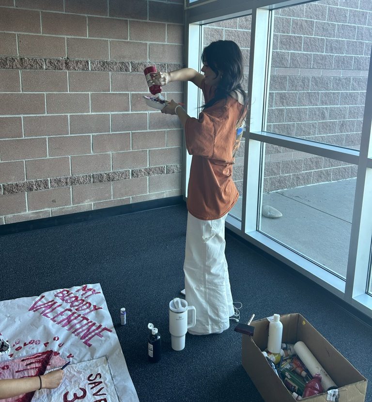 Megan Khazem ‘24 mixes paint while creating a poster for Key Club’s spring blood drive in the 8000s pod Feb. 1. This year’s theme is My Bloody Valentine. The drive will take place Feb. 7 in the auxiliary gym from 9:30 a.m. to 1:15 p.m. “Just one donation can save up to three lives and it really only takes about ten to fifteen minutes to get that donation,” Khazem said. “I think it’s 100% worth it to donate blood and help people in need.”