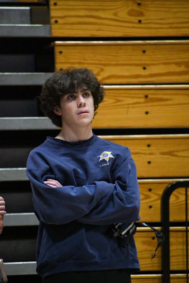 Before the start of the home dual, senior Bodey Sherrill stares at the gym scoreboard screens Jan. 31. The wrestling coaches compiled video highlights from the season and played them before the dual began. The seniors were then recognized individually. Senior Night was great, [we] got to recognize the great seniors and it was exciting walking out on the mat to get recognized, Sherill said.