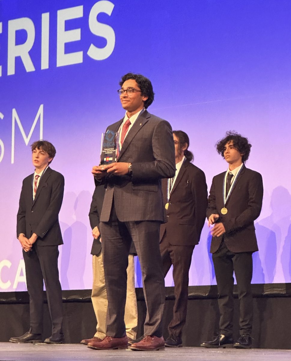 Holding his second place DECA Glass in the category of Automotive Series Marketing, Aditya Khanolkar ‘25 stands atop the Broadmoor stage at DECA State Feb. 27. Khanolkar is a veteran DECA member of two years, but this was his first time qualifying for an international competition.