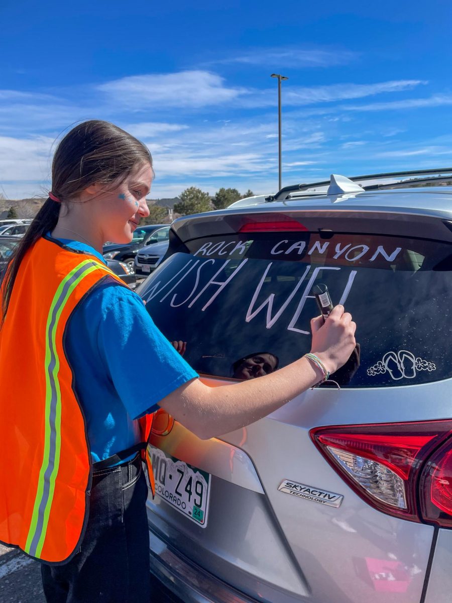 Student+Council+member+Sydney+Lowery+%E2%80%9825+paints+a+car+during+the+Walk+for+Wishes+Wish+Week+event+March+2.+Student+Council+began+setting+up+Walk+for+Wishes+at+8+a.m.+and+included+attractions+such+as+hair+tinsel%2C+henna+tattoos%2C+local+businesses%2C+food+trucks+and+car+painting+for+students+and+families.+%E2%80%9CThe+most+exciting+part+of+Wish+Week+for+me+is+getting+to+see+the+whole+school+and+community+come+together+for+such+a+good+cause+and+to+grant+someones+wish+who+struggles+every+day+and+watch+it+bring+joy+to+them+and+their+families+lives%2C%E2%80%9D+Lowery+said.
