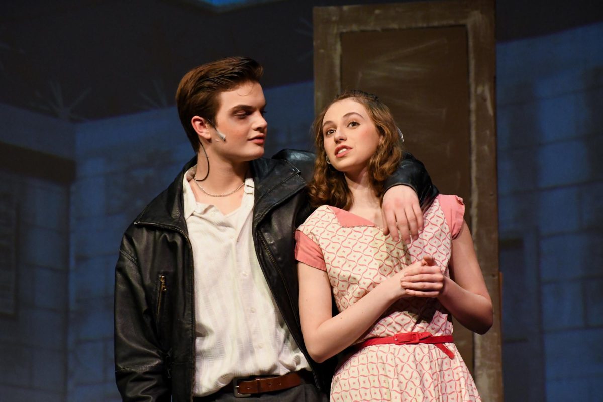 Lola Claggett ‘25 tries to slip herself away from Kyle Walsh ‘25 during the final dress rehearsal in the auditorium April 2. Kim, Claggett’s character, initially found herself head-over-heels for Conrad, played by Walsh. However, after spending time with Conrad alone, Kim quickly realizes her mistake and tries to find a way to return to her home. “A challenge I came across while playing Kim was being able to pinpoint when her opinion of Conrad changed,” Claggett said. “She has to love him at first and slowly start to see the gross person he is.  I had a hard time making that arc not only noticeable to the audience but also make sense and be in line with the rest of the plot.”