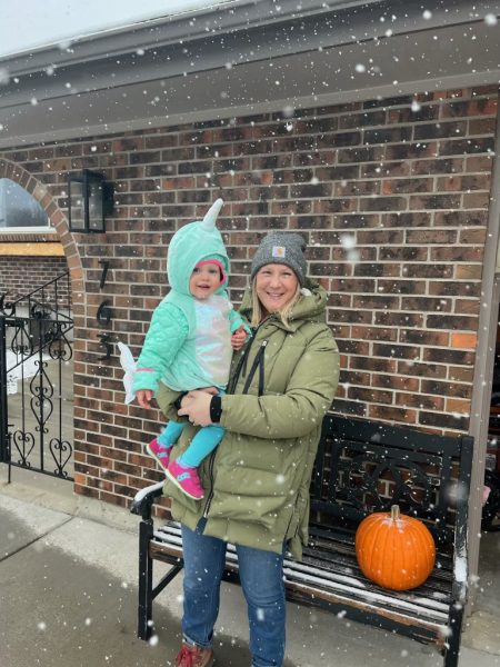 Science teacher Aby Boente smiles with her daughter as snow falls around them before the schools Trunk or Treat Oct. 30. Boentes family dressed up for the event and her daughter wore a Narwhal outfit to the event.