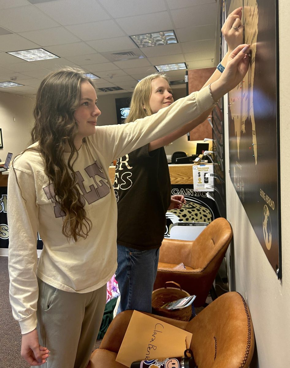 During Access, Clara Benko ‘24 and Ella Bearman ‘24 push their pins into the post-grad plan map in the Counseling Office April 23. Benko committed to Davidson College in North Carolina with an undecided major and Bearman committed to Wheaton College in Illinois with a major in English Literature and a minor in French. “[College] feels real now, which is kinda freaky but I’m really excited for college,” Bearman said. “Their English program [excited me most]. Their English building looks like a castle which is really fun.