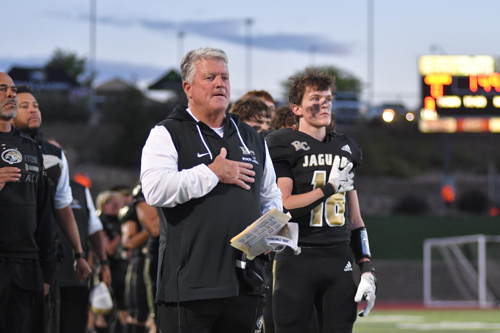 Varsity football coach Kevin Meyer stands for the national anthem before the homecoming game game against Grandview High School at EchoPark Stadium Sept. 20. Meyer coached the team for four years and led the team to a 4-7 season record before announcing his retirement Nov. 11. “We had a great four years going 26 to 21. It was a program that was really down, and it took a lot to get to where we are now,” Meyer said. 