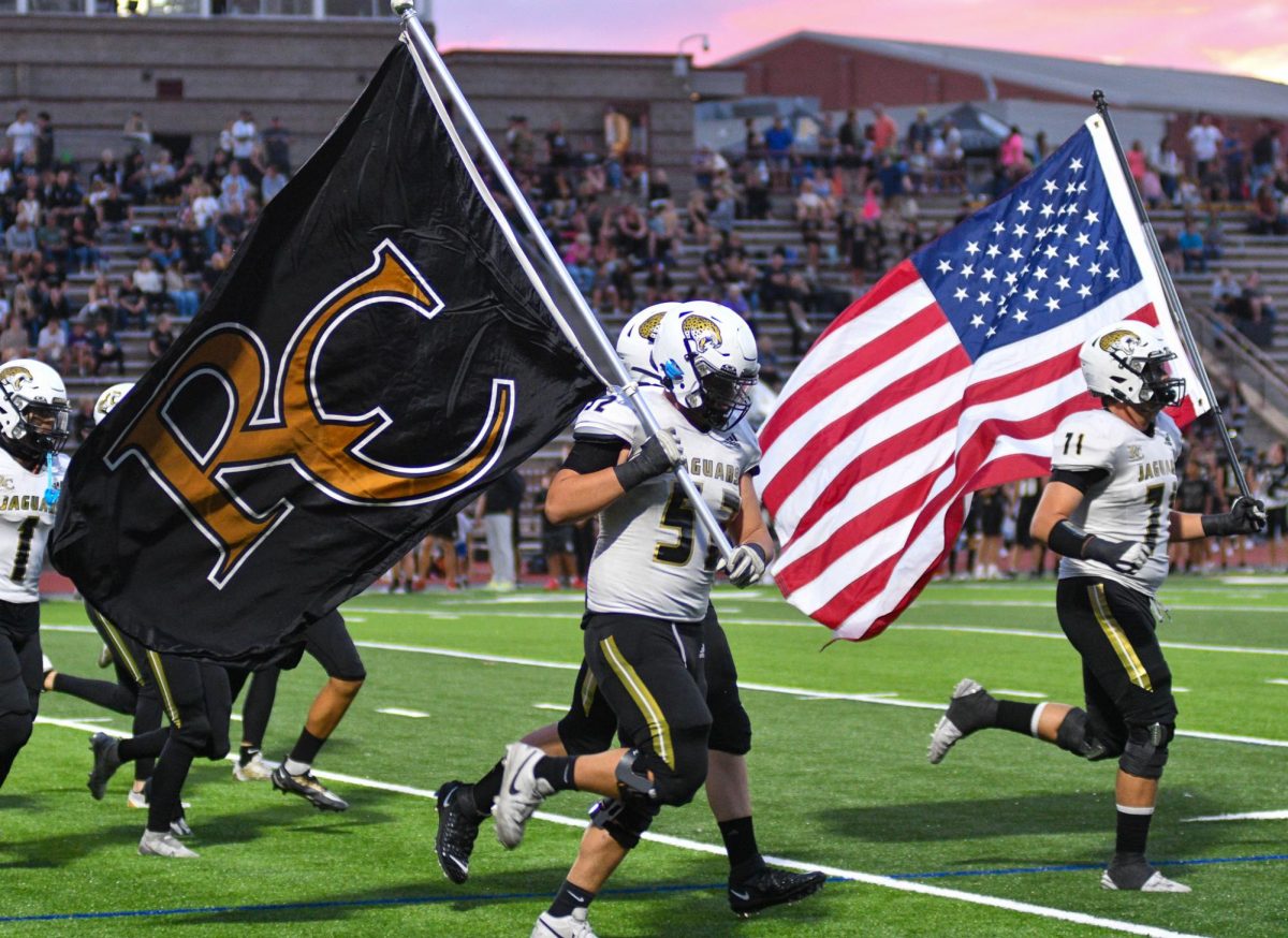 Guard Jake Lenertz ‘25 and offensive tackle Grant Carmann ‘25 run with flags before kickoff against Arapahoe High School (AHS) at Littleton Public School Stadium Sept. 26 at 7 p.m. The Jags lost 7-34L and their record is currently 2-3 . According to Max Preps, quarterback Josh Miller ‘25 threw 115 yards to wide receiver Timothy Huette who picked up 55 receiving yards. While running back Tyler Meyer ‘25 rushed 106 yards. “The game had a lot of negatives and positives, we as a collective were not on our game,” Lenertz said. “Everybody worked hard and our defense showed some light, we just need to come out the rest of the season on our game and come out of whatever hole we are in.” 