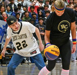 Mark Larson ‘25 puts pressure on English teacher Karen Witney during the Unified Team v. The Alliteration All-Stars game Feb. 4. The Alliteration All-Stars matched with knee-high socks and rainbow head and armbands. The Unified team sported their white Rock Canyon jerseys. 