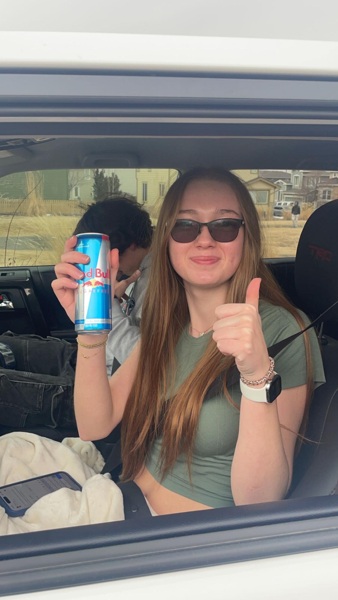 Lily Perry ‘27 holds a Red Bull in her car on Feb. 19. According to the USDA, the average amount of caffeine in a cup of coffee is 95 mg. Most energy drinks contain 100-300 mg of caffeine according to the Mayo Clinic Health System. “My favorite drink is Red Bull,” Perry said. “I drink about four or five in a week.”
