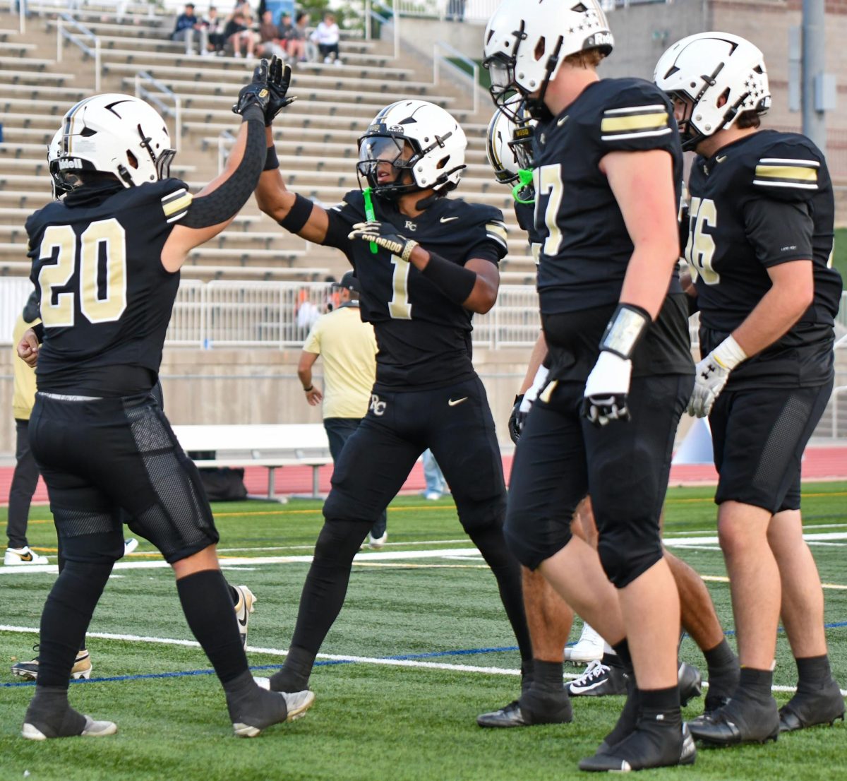 After the coin toss, running back Mason Mills ‘26 and wide receiver Ellis Watson ‘26 at 
Echo Park Stadium Sept. 5 for the home opener against Fossil Ridge High School (FRHS). Mills has had 58 rushing yards so far this season. “The coin toss is always where the worst nerves are and the hardest part is trying to control them. This game was just another team in our way. This doesn’t change our mind set or approach to any other games in the future. It is one game at a time, one week at a time. Everyone had a huge sense of accomplishment and hunger for the rest of the season,” Mills said.